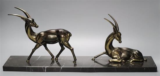 Two Art Deco cast gilt metal gazelles, on black veined marble plinth, 55cm